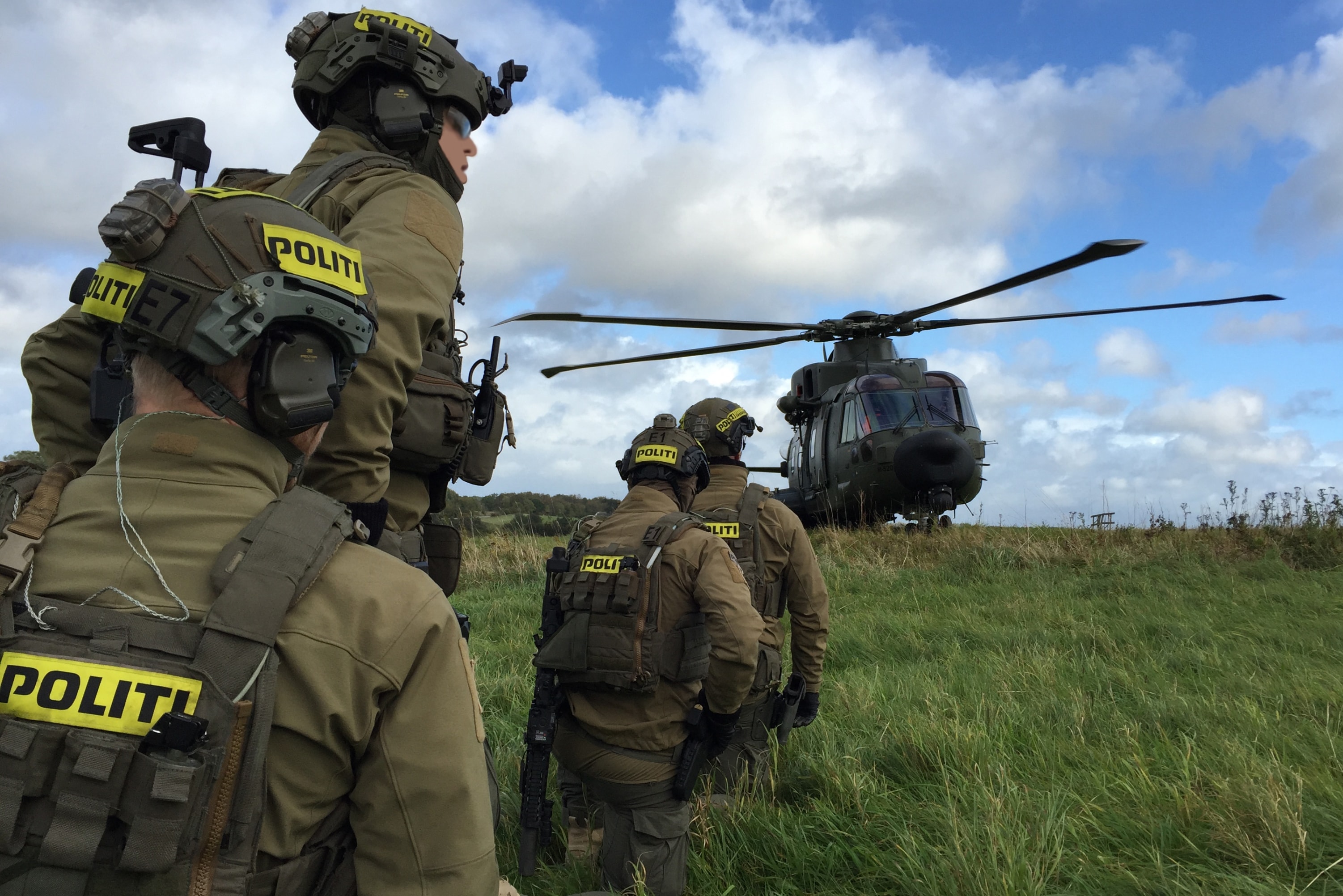 Fire mænd fra Aktionsstyrken på vej mod helikopter